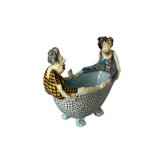 Figuren forestiller to personer, der sidder overfor hinanden i et badekar i en livlig og fortællende scene